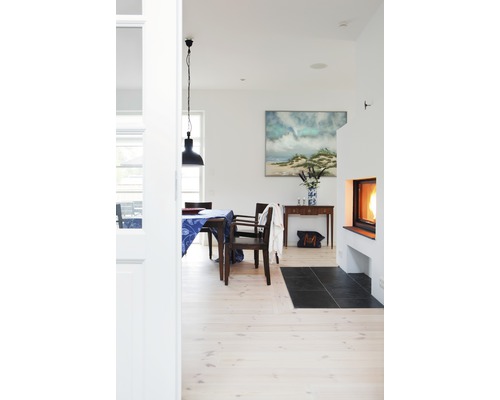 Ljust vardagsrum med matbord, öppen spis och dekoration