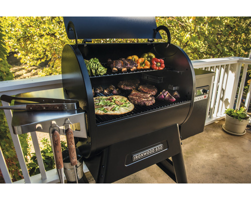 Grill med pizza, biffar, grönsaker och revben på grillgallret