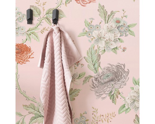 Vägg med blommig tapet, handduk på krok