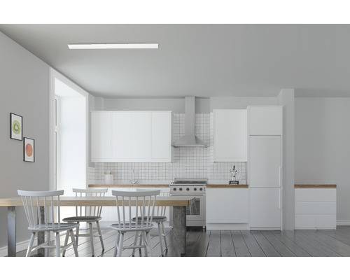 Ljust kök med vita skåp, matbord och stolar