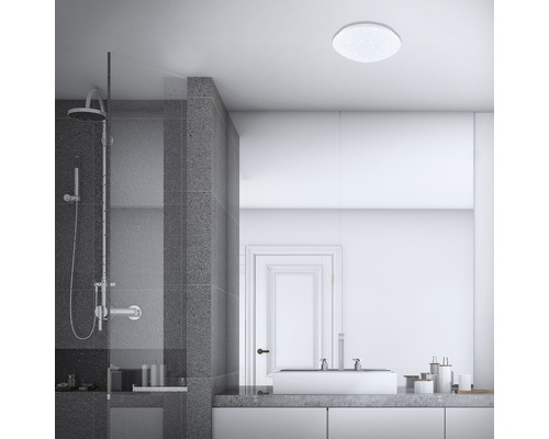 Badrum med dusch, handfat och rund taklampa