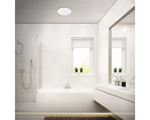 Ljust badrum med badkar, dusch, handfat och taklampa