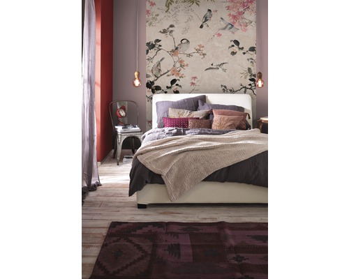 Sovrum med blommig tapet, säng och matta