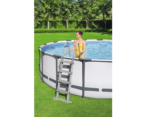 Ovanjordisk pool med stege i trädgården