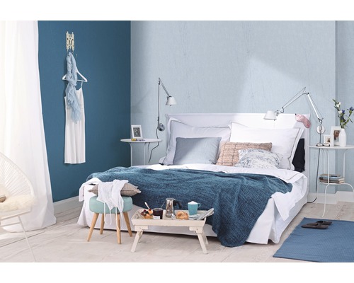 Modernt sovrum med säng, sängbord, textilier och dekorativa element