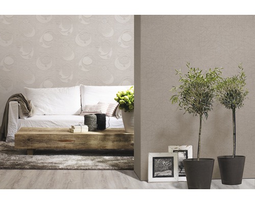 Vardagsrum med soffa, träbord, krukväxter och mönstrad tapet