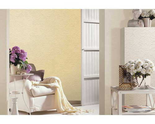 Vardagsrum med mönstrad tapet, fåtölj och dekoration