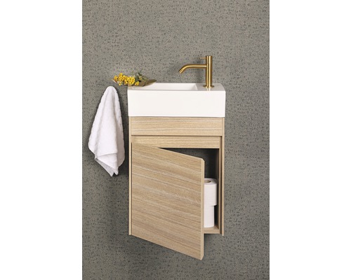 Litet tvättställ med öppet träskåp, handduk och armatur