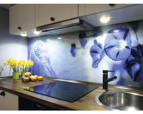 Köksscen med bänkskiva, diskho, kokplatta, stänkskydd med blommotiv och köksredskap