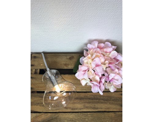 Glödlampslampa med blomsterarrangemang på trälåda