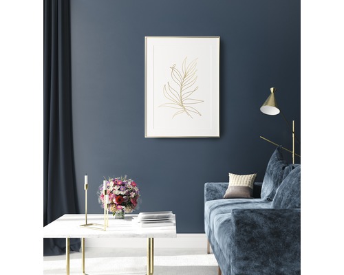 Vardagsrum med soffa, bord och inramad växtbild