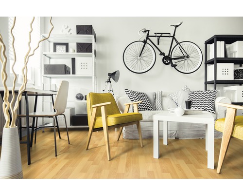 Vardagsrum med laminatgolv, soffa, fåtölj och hyllor