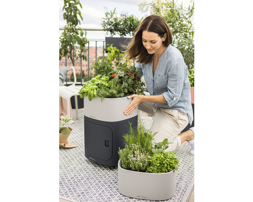 Kvinna med örtagård på balkong med planteringskärl och örter