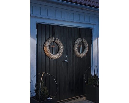 Dekorerad ytterdörr med kransar och växtlådor