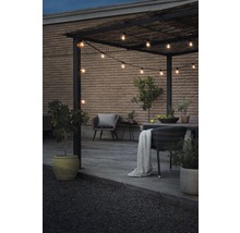Uteplats med pergola, ljusslinga och trädgårdsmöbler på en träterrass