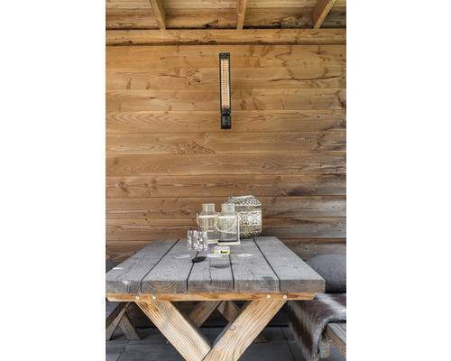 Terrass med träpanel, terrassvärmare och träbord med dekoration