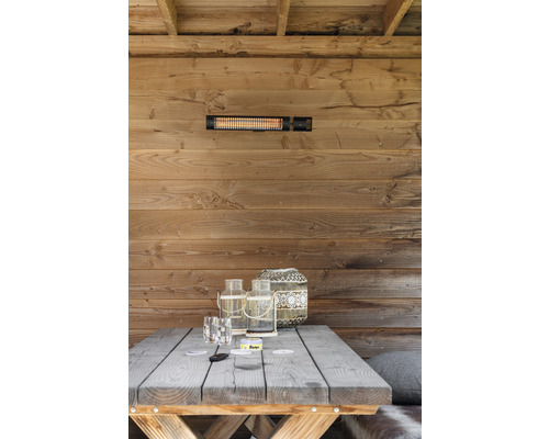 Scen med värmelampa på en trävägg ovanför ett träbord