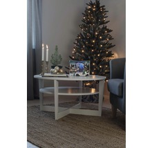 Julrumsscen med julgran, ljus och dekorationer på ett bord