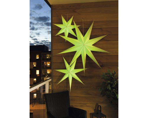 Dekorativa pappersstjärnor på en trävägg på en balkong