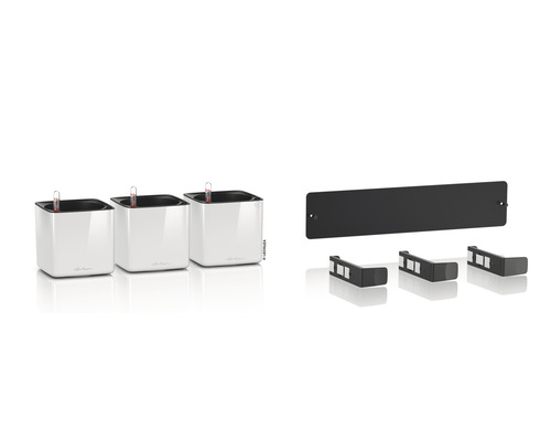 Tre vita blomkrukor med bevattningssystem och tillbehör för väggmontering.