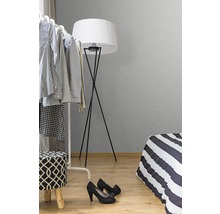 Sovrum med klädställning, golvlampa och säng