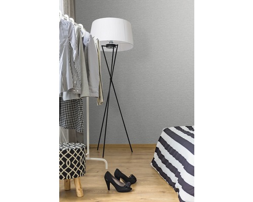 Sovrum med klädställning, golvlampa och säng