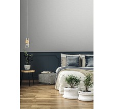 Sovrum med säng, sängbord, lampa, växter och tapet