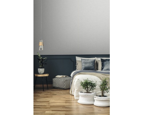 Sovrum med säng, sängbord, lampa, växter och tapet