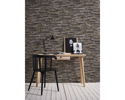 Inredning med skrivbord, stol, lampa och vägg i stenlook för arbetsrum eller kontor.