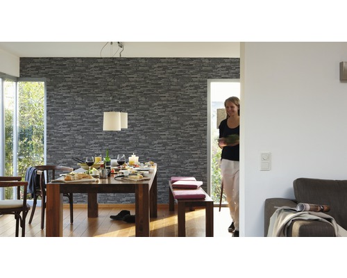 Matsal med matbord, stolar, bänk och tapet med stenutseende