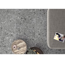 Grå klinkerplattor i interiör med soffa, bord och tidning