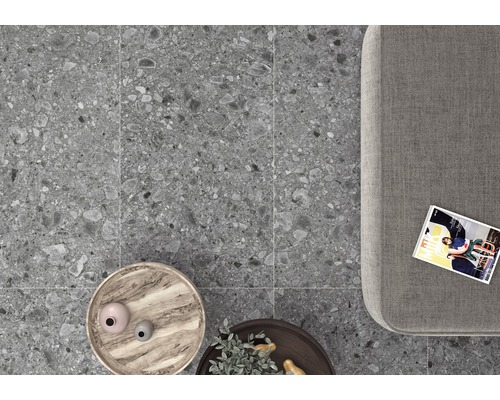 Grå klinkerplattor i interiör med soffa, bord och tidning