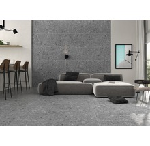 Vardagsrum med grå terrazzoplattor på golv och vägg