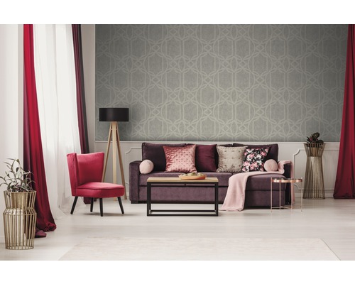 Vardagsrum med soffa, fåtölj, golvlampa och mönstrad tapet