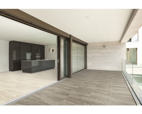 Terrass med plattor och skjutdörr till köket