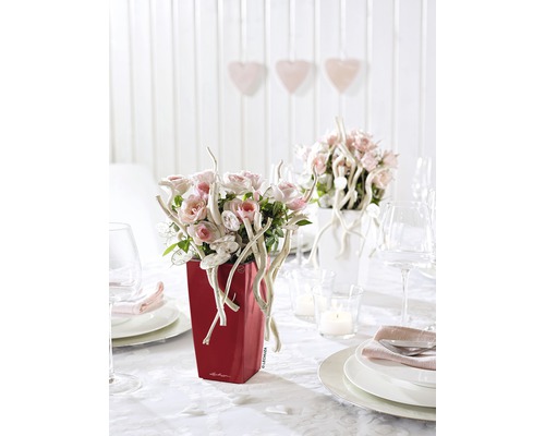 Dekorerat bord med röd blomlåda med blomsterarrangemang