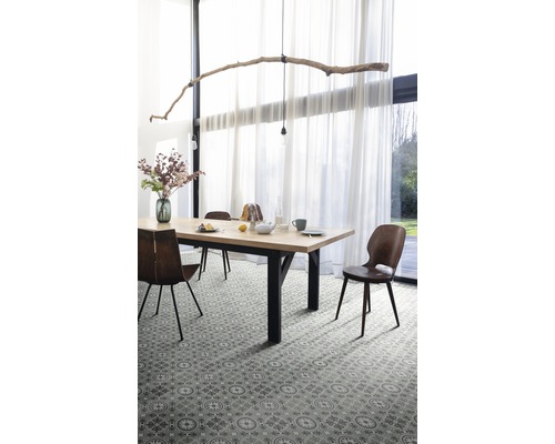 Matsal med bord, stolar och mönstrat golv.