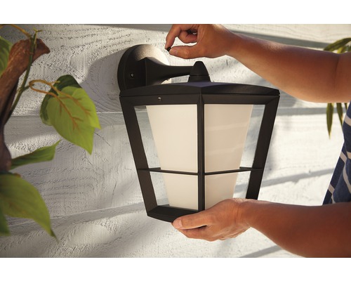 Installation av en svart yttervägglampa med frostad glasskärm