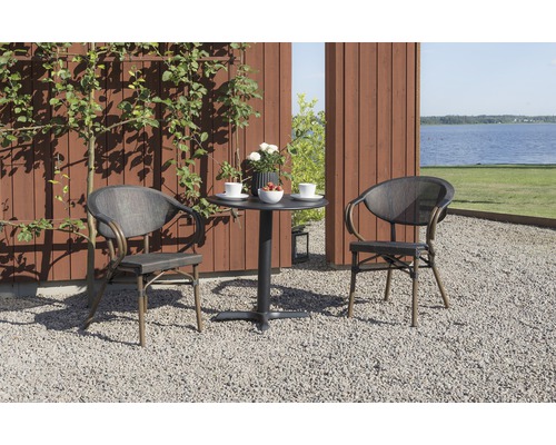 Trädgårdsscen med två stolar och ett bord på grus