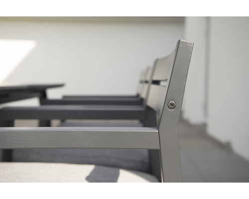 Detaljvy av trädgårdsstolar i trä med ryggstöd och armstöd.