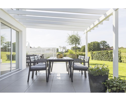 Uteplats med matbord, stolar och pergola