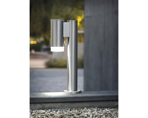 Utomhuslampa i rostfritt stål med rörelsesdetektor på en mur