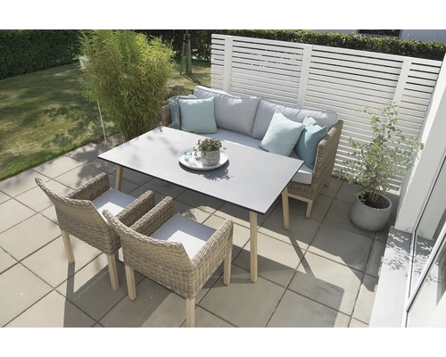 Uteplats med bord, bänk och stolar på en terrass.