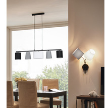 Matsal med matbord, stolar, taklampa med fem lampskärmar och vägglampa med tre lampskärmar