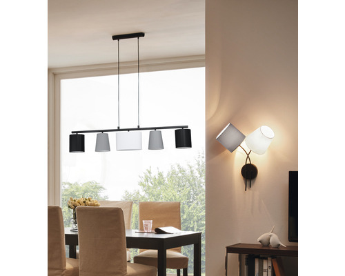 Matsal med matbord, stolar, taklampa med fem lampskärmar och vägglampa med tre lampskärmar