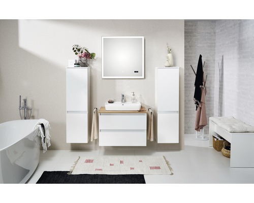 Badrum med handfat, spegel, högskåp, badkar och bänk