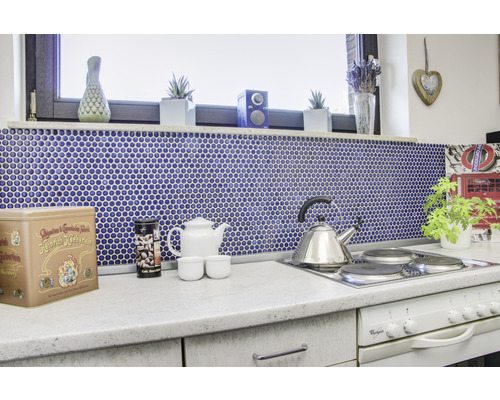 Köksscen med mosaik, tekanna och tillbehör på bänkskivan