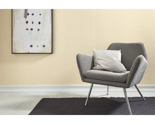 Miljö med mönstrad tapet, fåtölj, kudde, matta och tavla