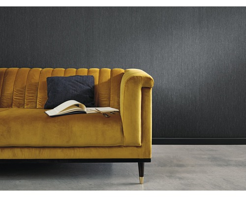 Vardagsrum med mönstrad tapet och gul soffa