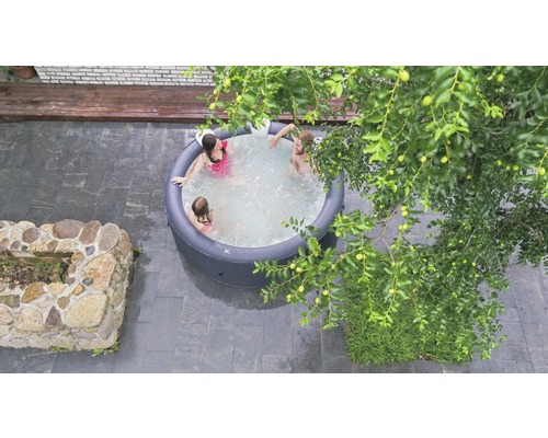 Ovanifrånvy av en uppblåsbar bubbelpool med människor i trädgården